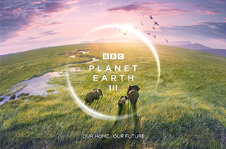 Planet Earth 3 logo over elephants crossing grassland. Credit: BBC Studios.